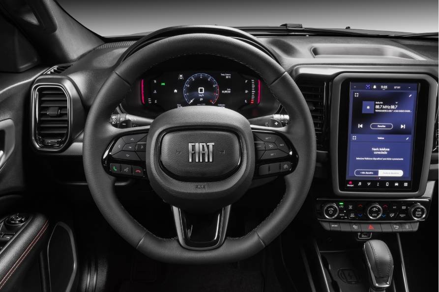 # Fiat Toro 2027 estreia sistema híbrido leve

## Picape passa a contar com tecnologia MHEV de 48V no Brasil

A Fiat apresentou a linha 2027 da Toro com a estreia do sistema híbrido-leve MHEV de 48V, tornando o modelo a primeira picape produzida no Brasil a receber a tecnologia. O conjunto passa a equipar as versões Volcano e Ultra com motor Turbo 270 Flex.

Segundo a fabricante, o sistema híbrido-leve combina o motor a combustão com um sistema elétrico de baixa tensão, permitindo redução no consumo de combustível e nas emissões de CO² sem necessidade de recarga externa.

De acordo com a marca, a tecnologia pode proporcionar economia de combustível de até 12% e redução de aproximadamente 11% nas emissões de CO².

## Como funciona o sistema híbrido-leve da Toro?

O sistema MHEV de 48V utiliza um motor elétrico multifuncional que auxilia o motor a combustão em situações de aceleração e recuperação de energia durante desacelerações.

A estratégia chamada de coasting-regen aproveita a energia cinética gerada nas frenagens e desacelerações para recarregar automaticamente a bateria de 48V.

Além da eficiência energética, a Fiat informa que o sistema entrega até 65 Nm de torque elétrico adicional, melhorando as respostas nas acelerações.

Dependendo da legislação de cada estado, veículos híbridos podem contar com benefícios como descontos ou isenção de IPVA e liberação do rodízio municipal em cidades como São Paulo.

## Toro amplia pacote de segurança

Outra novidade da linha 2027 é a ampliação dos sistemas avançados de assistência ao motorista (ADAS) em todas as versões da picape.

A partir de agora, toda a gama passa a contar de série com alerta de colisão com frenagem automática, alerta de mudança de faixa e comutador automático de farol alto.

As versões Ultra e Ranch recebem ainda sensor de ponto cego e alerta de tráfego cruzado traseiro como itens de série. Na Volcano, os recursos passam a ser opcionais.

### Mudanças no design e conectividade

A Fiat também atualizou elementos visuais da Toro. A assinatura em LED dianteira ganhou seta sequencial integrada, enquanto o conjunto óptico segue com iluminação full LED.

O modelo mantém painel digital de 7 polegadas e central multimídia de até 10,1 polegadas nas versões superiores. A linha também conta com freio de estacionamento eletrônico, Auto Hold e conectividade Fiat Connect////Me.

“A Fiat Toro chega à linha 2027 consolidando uma trajetória de sucesso no mercado automotivo. Desde o seu lançamento, há 10 anos, o modelo se mantém líder de vendas em seu segmento, reflexo direto da sua proposta inovadora em unir a robustez de uma picape com o conforto de um SUV. A Toro nasceu para revolucionar o mercado de picapes ao unir tecnologia e versatilidade de forma inédita, e continua evoluindo com esse mesmo espírito pioneiro. Agora, com a chegada das versões MHEV, damos mais um passo importante ao oferecer mais eficiência e desempenho, tornando o modelo ainda mais competitivo e alinhado às demandas do mercado”, afirma Frederico Battaglia, Head das marcas Fiat e Abarth para a América do Sul.

## Motores e versões disponíveis

A linha 2027 da Fiat Toro será comercializada com três opções de motorização: Turbo 270 Flex, Turbo 270 Flex MHEV e 2.2 Turbodiesel.

O motor Turbo 270 Flex MHEV entrega 176 cv de potência e 270 Nm de torque. Já o motor 2.2 Turbodiesel oferece 200 cv e 450 Nm de torque nas versões Ranch e Volcano Diesel.

Com mais de 650 mil unidades produzidas em dez anos, a Toro segue como um dos modelos de maior volume no segmento de picapes intermediárias no Brasil.

### Preços da Fiat Toro 2027

* Endurance Turbo Flex – R$ 167.490
* Freedom Turbo Flex – R$ 177.490
* Volcano Turbo Flex MHEV – R$ 197.490
* Ultra Turbo Flex MHEV – R$ 206.490
* Volcano Diesel – R$ 220.490
* Ranch Diesel – R$ 238.490

**Tags:** Fiat Toro, Fiat Toro 2027, Toro híbrida, picape híbrida, MHEV 48V, Fiat, picape flex, Toro Volcano, Toro Ultra, mercado automotivo, picapes no Brasil, híbridos leves

