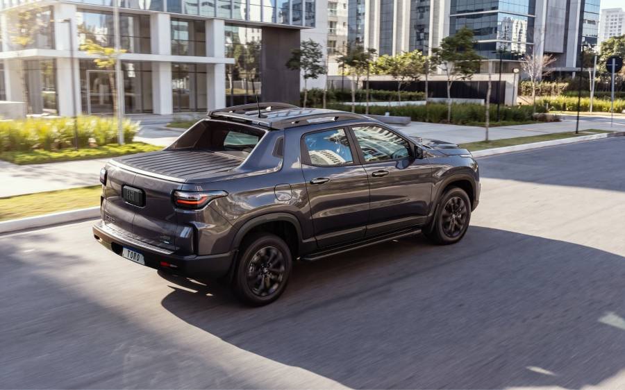 # Fiat Toro 2027 estreia sistema híbrido leve

## Picape passa a contar com tecnologia MHEV de 48V no Brasil

A Fiat apresentou a linha 2027 da Toro com a estreia do sistema híbrido-leve MHEV de 48V, tornando o modelo a primeira picape produzida no Brasil a receber a tecnologia. O conjunto passa a equipar as versões Volcano e Ultra com motor Turbo 270 Flex.

Segundo a fabricante, o sistema híbrido-leve combina o motor a combustão com um sistema elétrico de baixa tensão, permitindo redução no consumo de combustível e nas emissões de CO² sem necessidade de recarga externa.

De acordo com a marca, a tecnologia pode proporcionar economia de combustível de até 12% e redução de aproximadamente 11% nas emissões de CO².

## Como funciona o sistema híbrido-leve da Toro?

O sistema MHEV de 48V utiliza um motor elétrico multifuncional que auxilia o motor a combustão em situações de aceleração e recuperação de energia durante desacelerações.

A estratégia chamada de coasting-regen aproveita a energia cinética gerada nas frenagens e desacelerações para recarregar automaticamente a bateria de 48V.

Além da eficiência energética, a Fiat informa que o sistema entrega até 65 Nm de torque elétrico adicional, melhorando as respostas nas acelerações.

Dependendo da legislação de cada estado, veículos híbridos podem contar com benefícios como descontos ou isenção de IPVA e liberação do rodízio municipal em cidades como São Paulo.

## Toro amplia pacote de segurança

Outra novidade da linha 2027 é a ampliação dos sistemas avançados de assistência ao motorista (ADAS) em todas as versões da picape.

A partir de agora, toda a gama passa a contar de série com alerta de colisão com frenagem automática, alerta de mudança de faixa e comutador automático de farol alto.

As versões Ultra e Ranch recebem ainda sensor de ponto cego e alerta de tráfego cruzado traseiro como itens de série. Na Volcano, os recursos passam a ser opcionais.

### Mudanças no design e conectividade

A Fiat também atualizou elementos visuais da Toro. A assinatura em LED dianteira ganhou seta sequencial integrada, enquanto o conjunto óptico segue com iluminação full LED.

O modelo mantém painel digital de 7 polegadas e central multimídia de até 10,1 polegadas nas versões superiores. A linha também conta com freio de estacionamento eletrônico, Auto Hold e conectividade Fiat Connect////Me.

“A Fiat Toro chega à linha 2027 consolidando uma trajetória de sucesso no mercado automotivo. Desde o seu lançamento, há 10 anos, o modelo se mantém líder de vendas em seu segmento, reflexo direto da sua proposta inovadora em unir a robustez de uma picape com o conforto de um SUV. A Toro nasceu para revolucionar o mercado de picapes ao unir tecnologia e versatilidade de forma inédita, e continua evoluindo com esse mesmo espírito pioneiro. Agora, com a chegada das versões MHEV, damos mais um passo importante ao oferecer mais eficiência e desempenho, tornando o modelo ainda mais competitivo e alinhado às demandas do mercado”, afirma Frederico Battaglia, Head das marcas Fiat e Abarth para a América do Sul.

## Motores e versões disponíveis

A linha 2027 da Fiat Toro será comercializada com três opções de motorização: Turbo 270 Flex, Turbo 270 Flex MHEV e 2.2 Turbodiesel.

O motor Turbo 270 Flex MHEV entrega 176 cv de potência e 270 Nm de torque. Já o motor 2.2 Turbodiesel oferece 200 cv e 450 Nm de torque nas versões Ranch e Volcano Diesel.

Com mais de 650 mil unidades produzidas em dez anos, a Toro segue como um dos modelos de maior volume no segmento de picapes intermediárias no Brasil.

### Preços da Fiat Toro 2027

* Endurance Turbo Flex – R$ 167.490
* Freedom Turbo Flex – R$ 177.490
* Volcano Turbo Flex MHEV – R$ 197.490
* Ultra Turbo Flex MHEV – R$ 206.490
* Volcano Diesel – R$ 220.490
* Ranch Diesel – R$ 238.490

**Tags:** Fiat Toro, Fiat Toro 2027, Toro híbrida, picape híbrida, MHEV 48V, Fiat, picape flex, Toro Volcano, Toro Ultra, mercado automotivo, picapes no Brasil, híbridos leves
